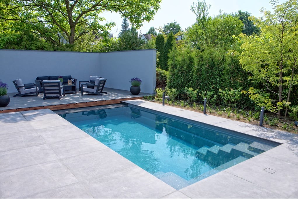 Modern courtyard swimming pool with raised hardwood lounge deck and curved screen wall in Belgravia, Harare