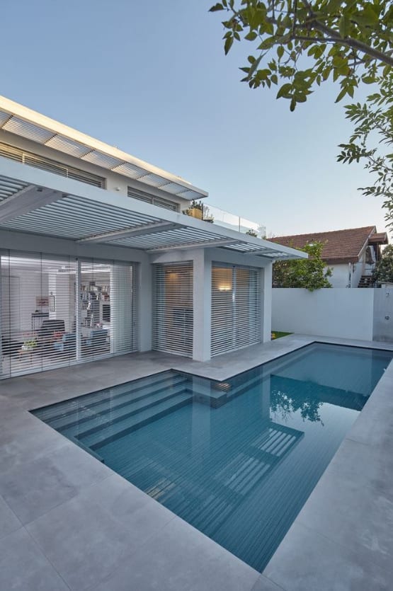 Swimming pool with adjustable louvre pergola and flush-threshold sliding glazing at a Borrowdale home in Harare