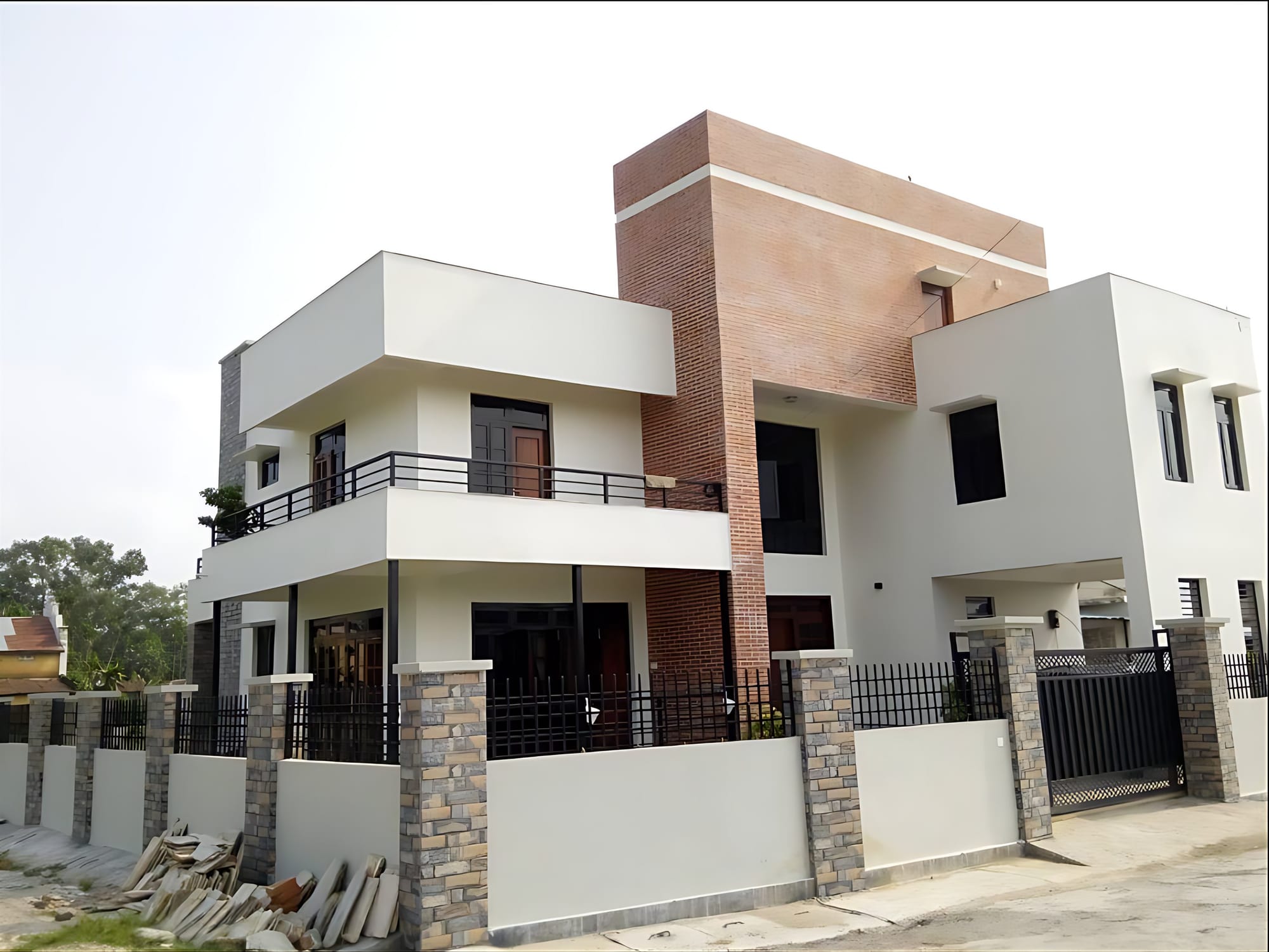 Completed double-storey modern residence in Gunhill Harare with white rendered volumes, face-brick tower and stone-clad boundary wall